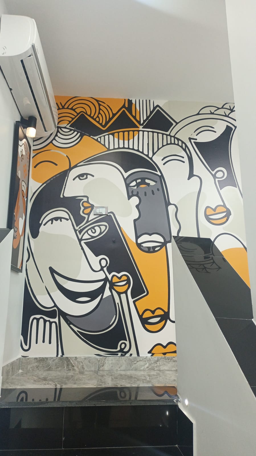 Cubist faces mural on the stairwell wall at Gala Clinics